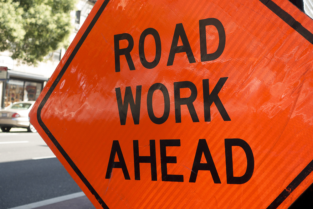 diamond shaped orange red reflector street sign that reads road diamond shaped orange red reflector street sign that reads road